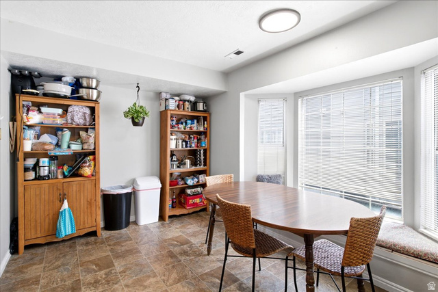 Dining area featuring a bay window with integrated window seating and horizontal blinds