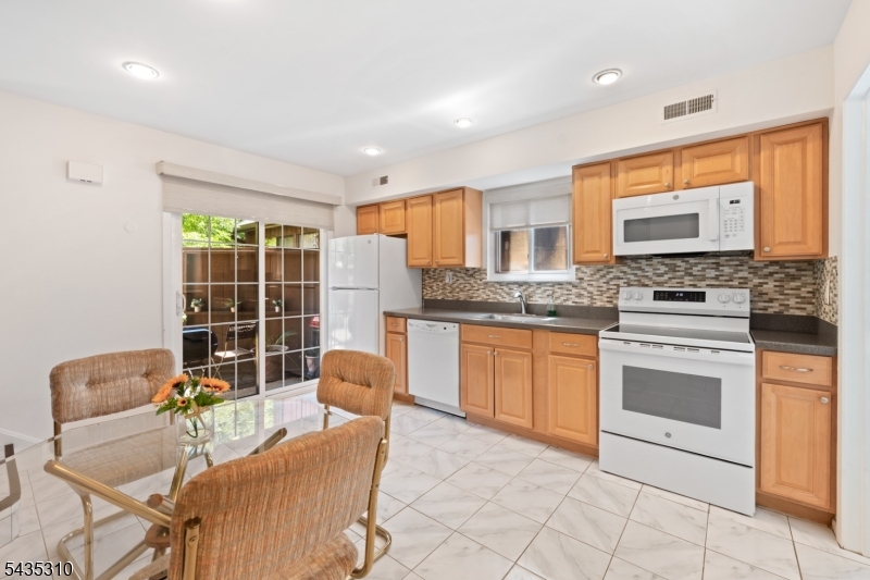 488 Auten Road, Unit 2D Hillsborough, NJ 08844 - Photo 10 of 30 a kitchen with granite countertop a stove a sink a dining table and chairs