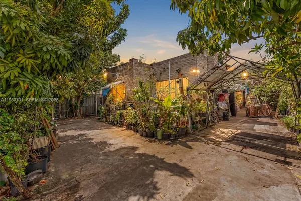 a view of a yard with plants and trees