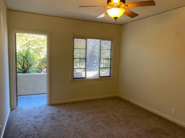 an empty room with a window and a chandelier