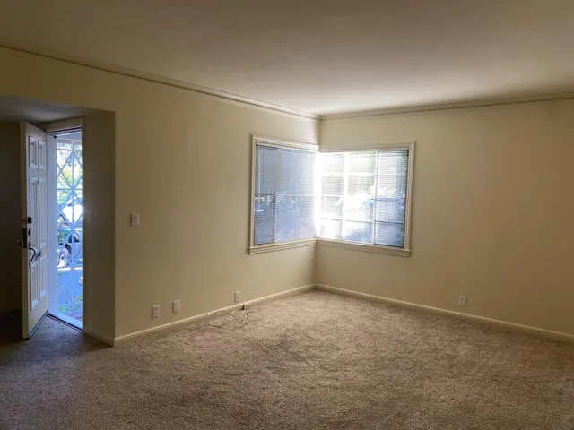 an empty room with windows and closet
