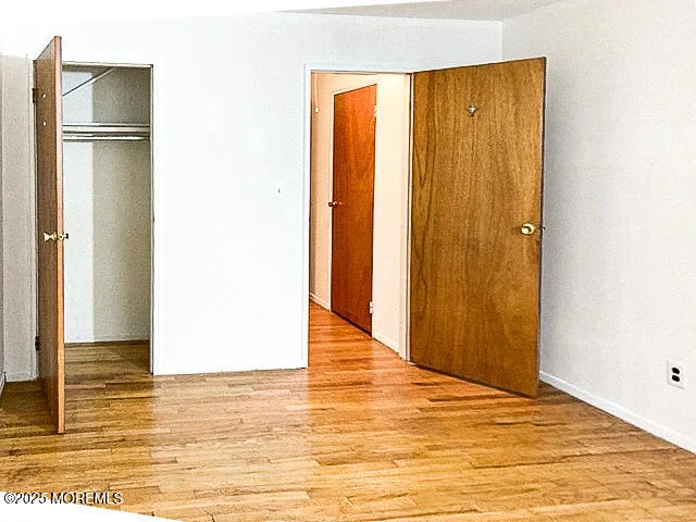 a view of empty room with wooden floor and wall painting