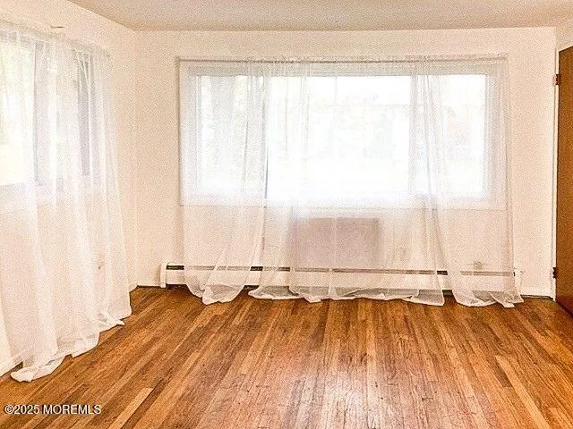 a view of a room with wooden floor and a window