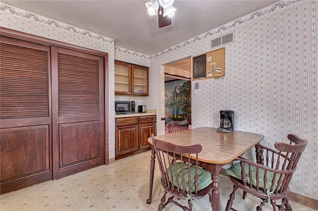 a kitchen with a dining table chairs and refrigerator