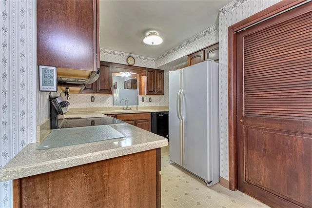 a kitchen with stainless steel appliances granite countertop a refrigerator a sink and a stove