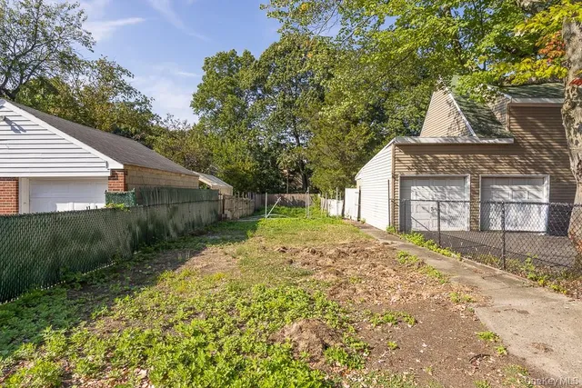 a view of yard with green space and wooden fence
