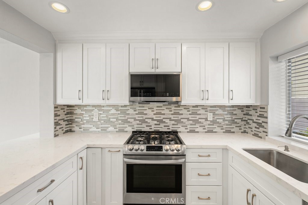 4 Las Cruces Irvine, CA 92614 - Photo 11 of 33 a kitchen with cabinets stainless steel appliances a sink and a stove
