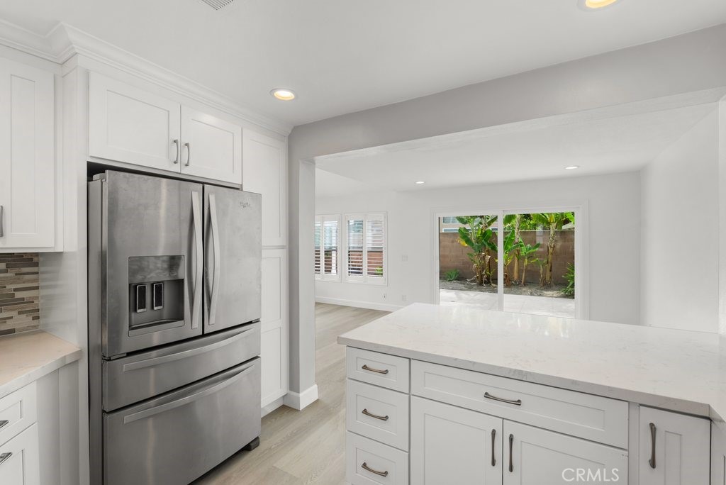 4 Las Cruces Irvine, CA 92614 - Photo 12 of 33 a kitchen with white cabinets and stainless steel appliances