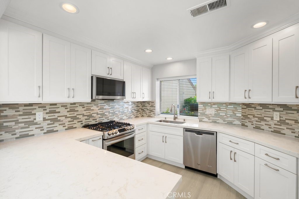 4 Las Cruces Irvine, CA 92614 - Photo 9 of 33 a kitchen with a sink stove top oven and cabinets