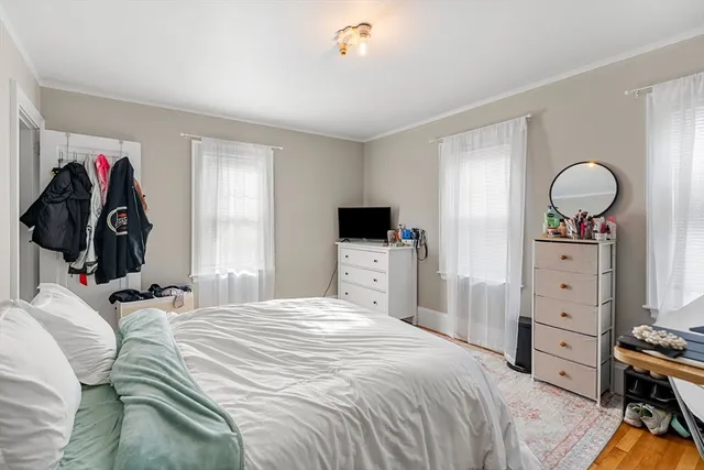a bedroom with a bed and a flat tv screen on the dresser
