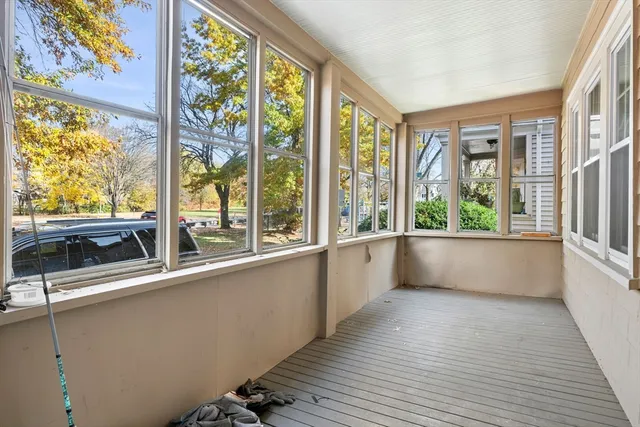 a view of a large room with wooden floor and a window