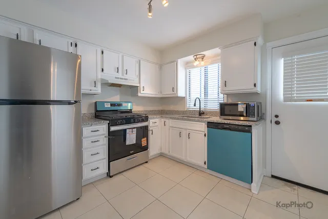 a kitchen with cabinets a refrigerator and a stove