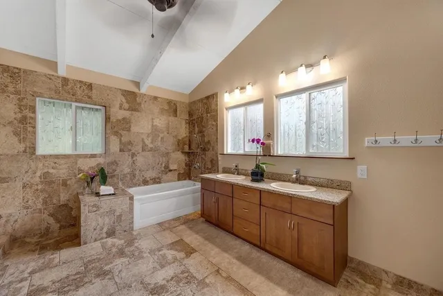 a bathroom with a tub sink and mirror