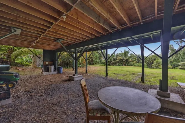 a view of a backyard with table and chairs under an umbrella