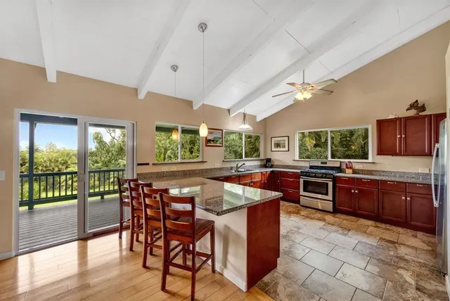 a kitchen with stainless steel appliances granite countertop sink stove and wooden cabinets