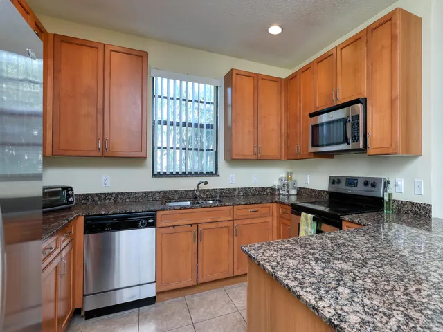 a kitchen with stainless steel appliances granite countertop a sink stove and microwave
