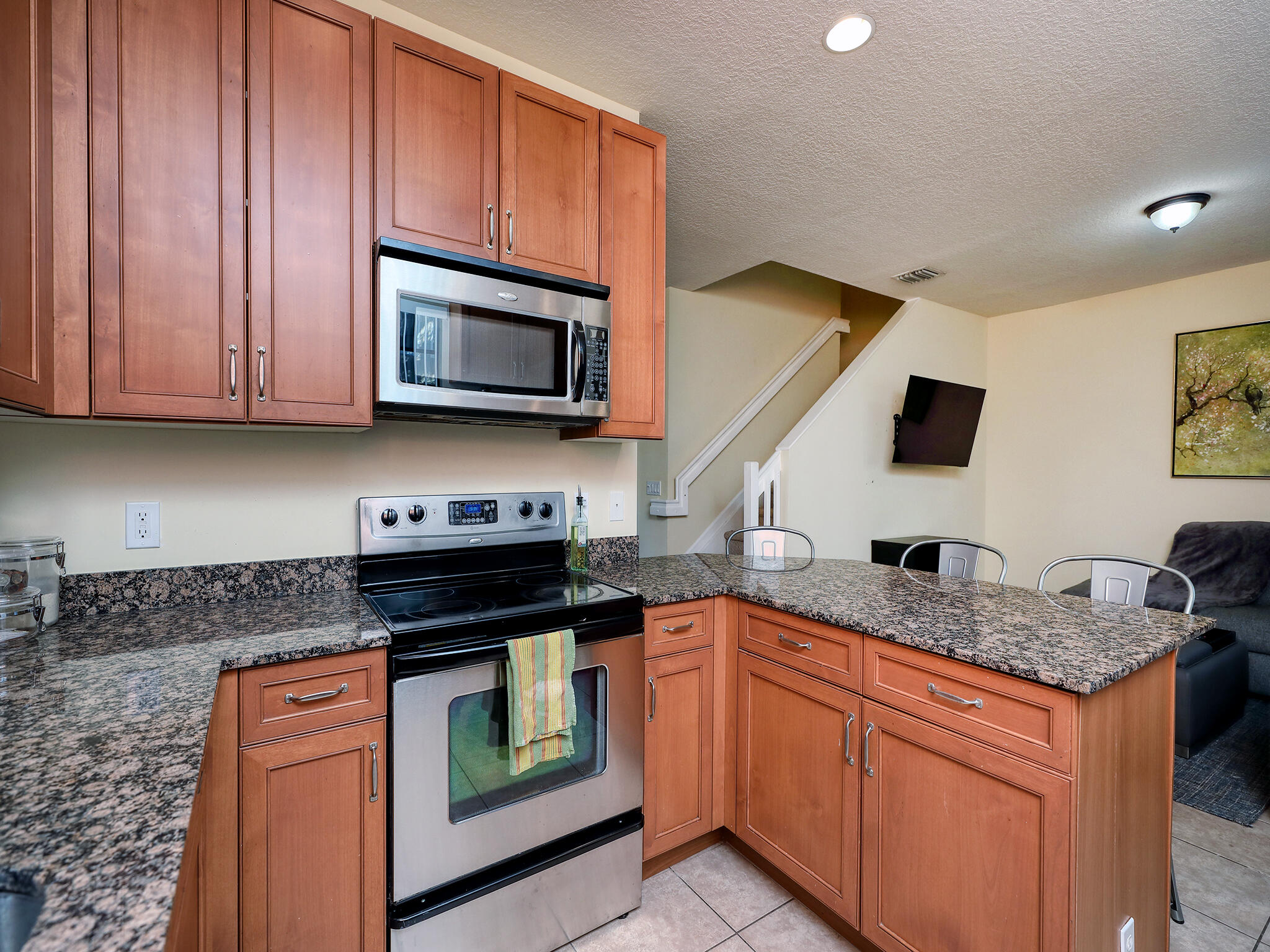 102 Astor Circle Delray Beach, FL 33484 - Photo 14 of 29 a kitchen with granite countertop a sink stove and microwave