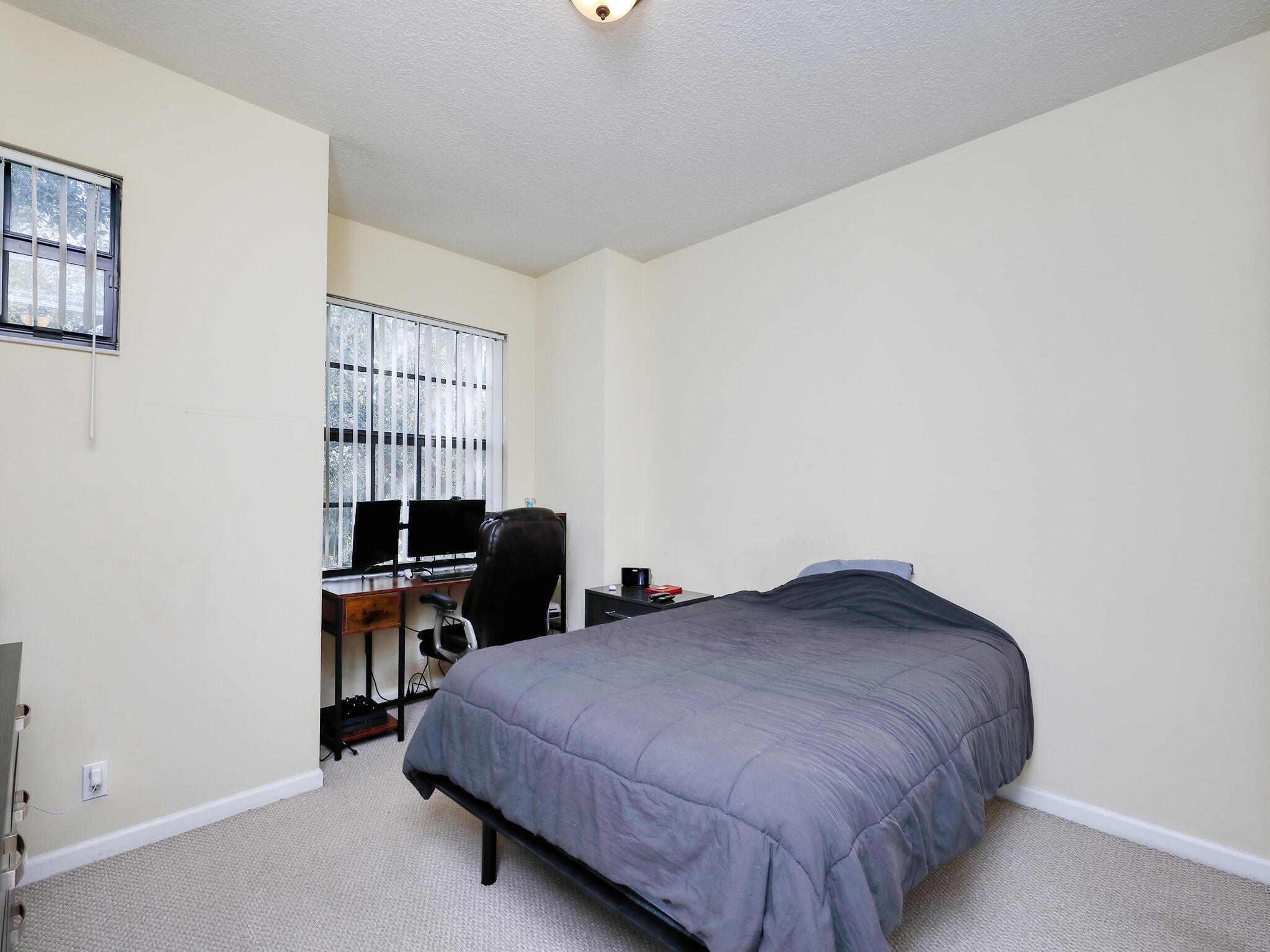 102 Astor Circle Delray Beach, FL 33484 - Photo 19 of 29 a bedroom with a bed and a desk in it