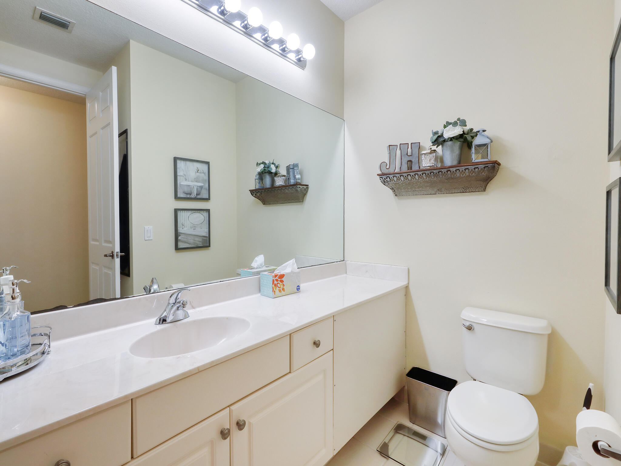102 Astor Circle Delray Beach, FL 33484 - Photo 22 of 29 a bathroom with a granite countertop toilet sink and mirror