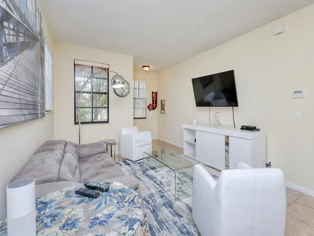 a living room with furniture a flat screen tv and kitchen view