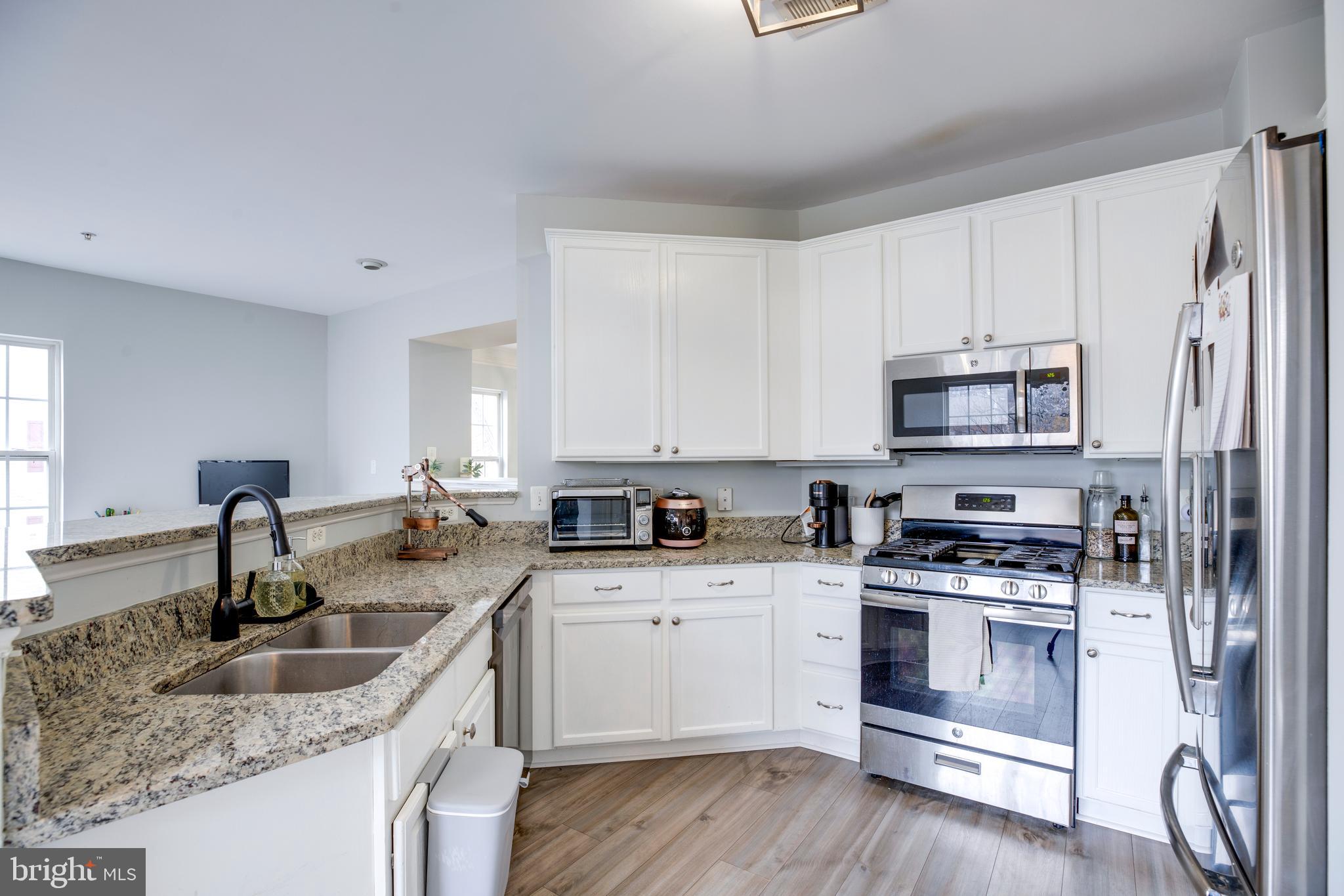 8069 Gatehouse Road, Unit 23 Falls Church, VA 22042 - Photo 13 of 43 a kitchen with stainless steel appliances granite countertop a sink stove and refrigerator