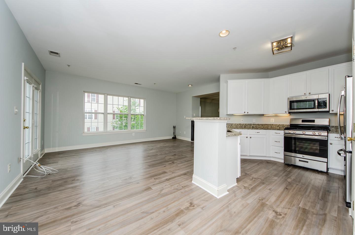 8069 Gatehouse Road, Unit 23 Falls Church, VA 22042 - Photo 15 of 43 a kitchen with wooden floors and white appliances