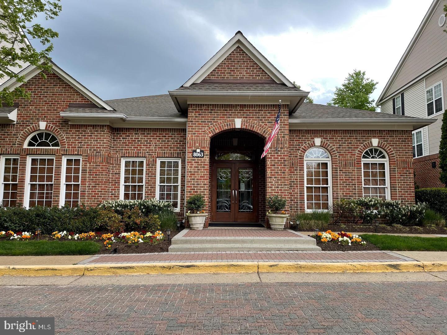 8069 Gatehouse Road, Unit 23 Falls Church, VA 22042 - Photo 41 of 43 a front view of a house with lots of windows and plants