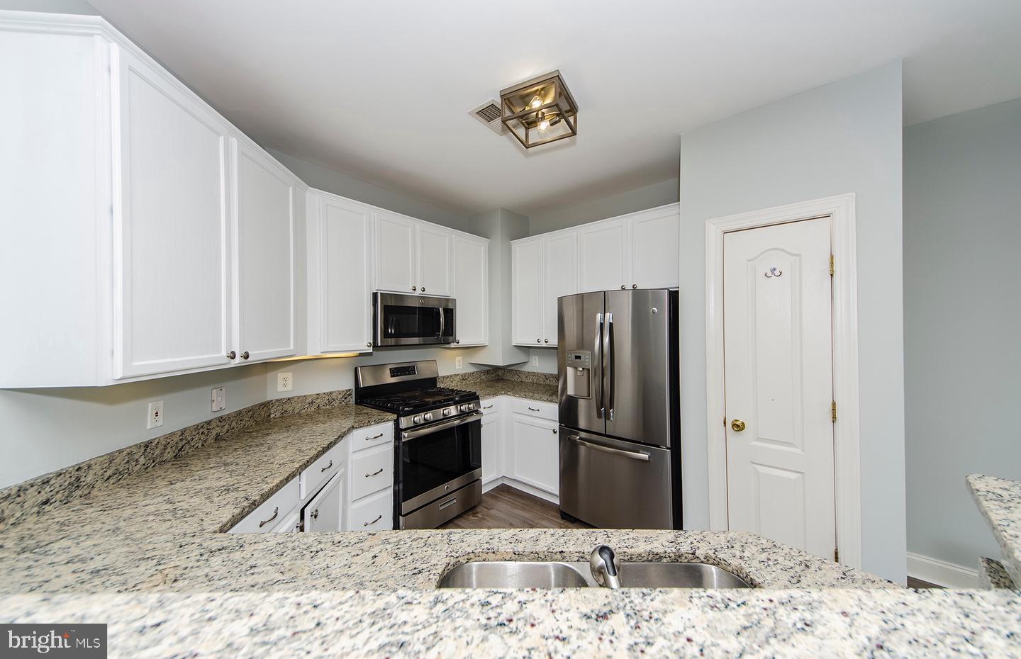 8069 Gatehouse Road, Unit 23 Falls Church, VA 22042 - Photo 9 of 43 a kitchen with a refrigerator sink and cabinets