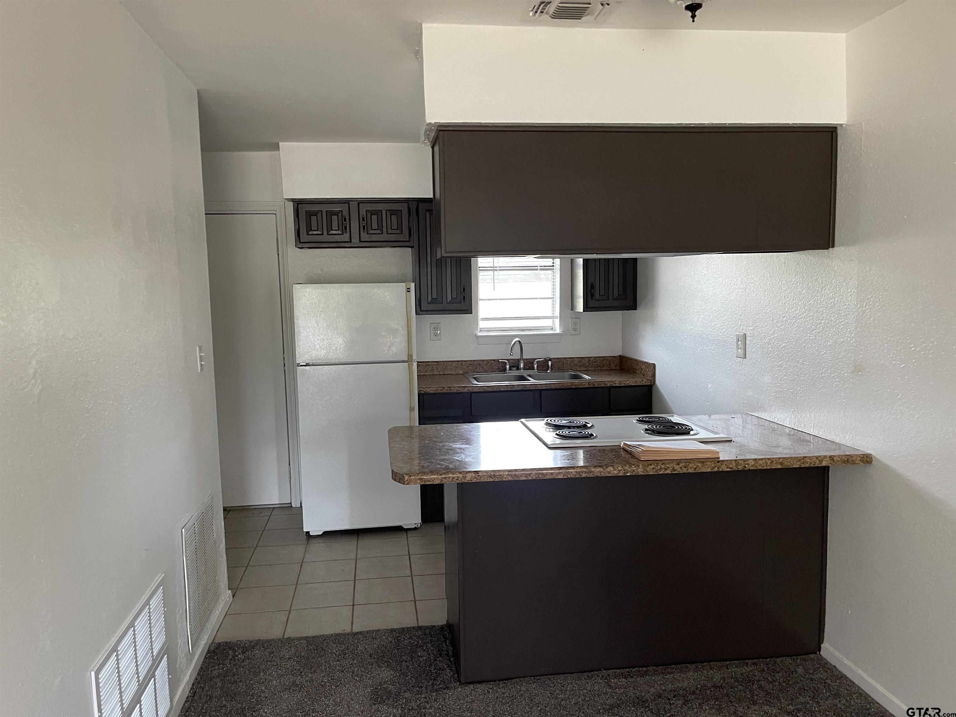 315 Circle Drive, Unit 2 Bogata, TX 75417 - Photo 3 of 11 a kitchen with a refrigerator and a stove