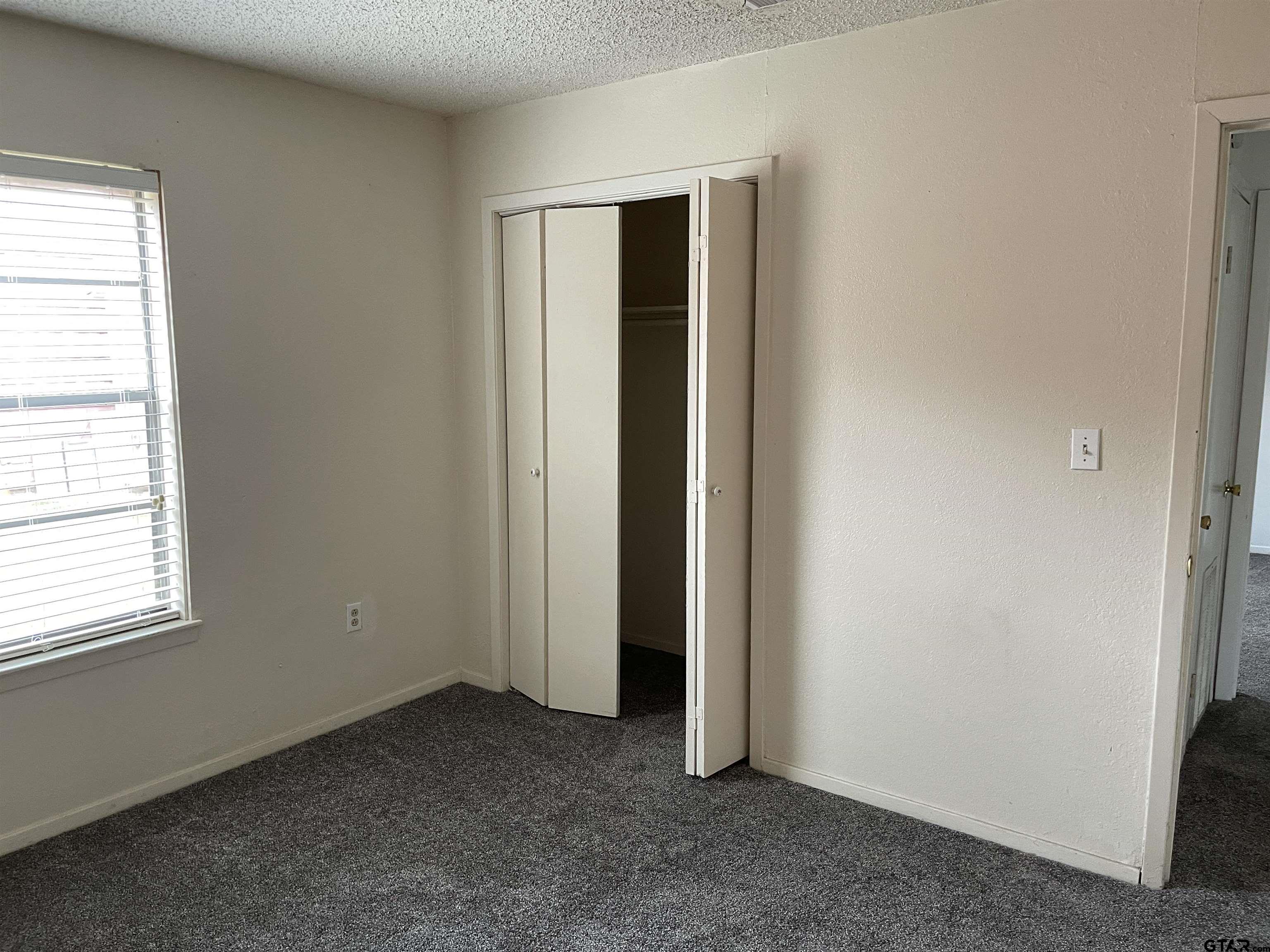 315 Circle Drive, Unit 2 Bogata, TX 75417 - Photo 10 of 11 an empty room with windows and closet