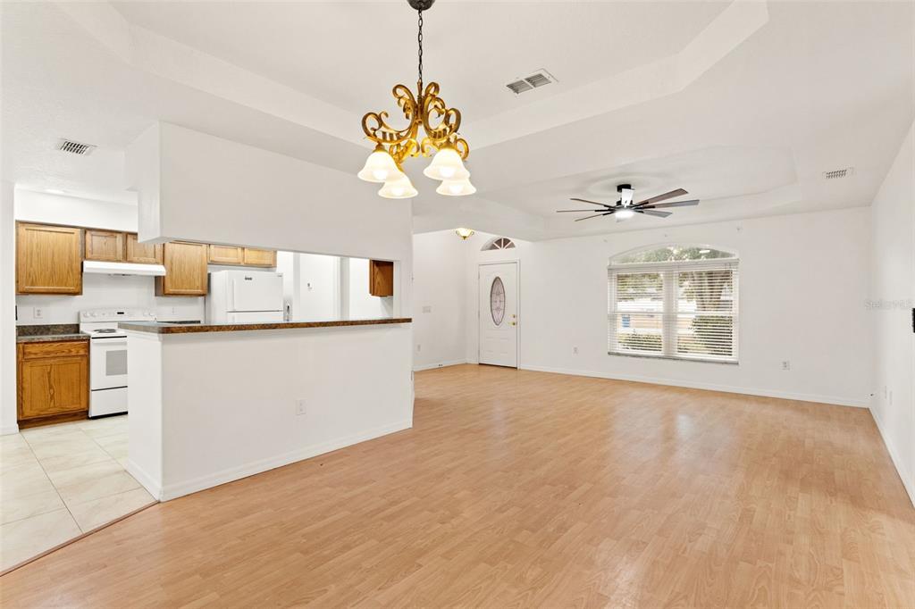542 Fairbanks Road Spring Hill, FL 34608 - Photo 18 of 45 a view of a kitchen with a sink dishwasher a stove top oven a refrigerator with a dining table and chairs