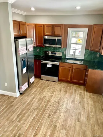 a kitchen with stainless steel appliances granite countertop a refrigerator and a sink