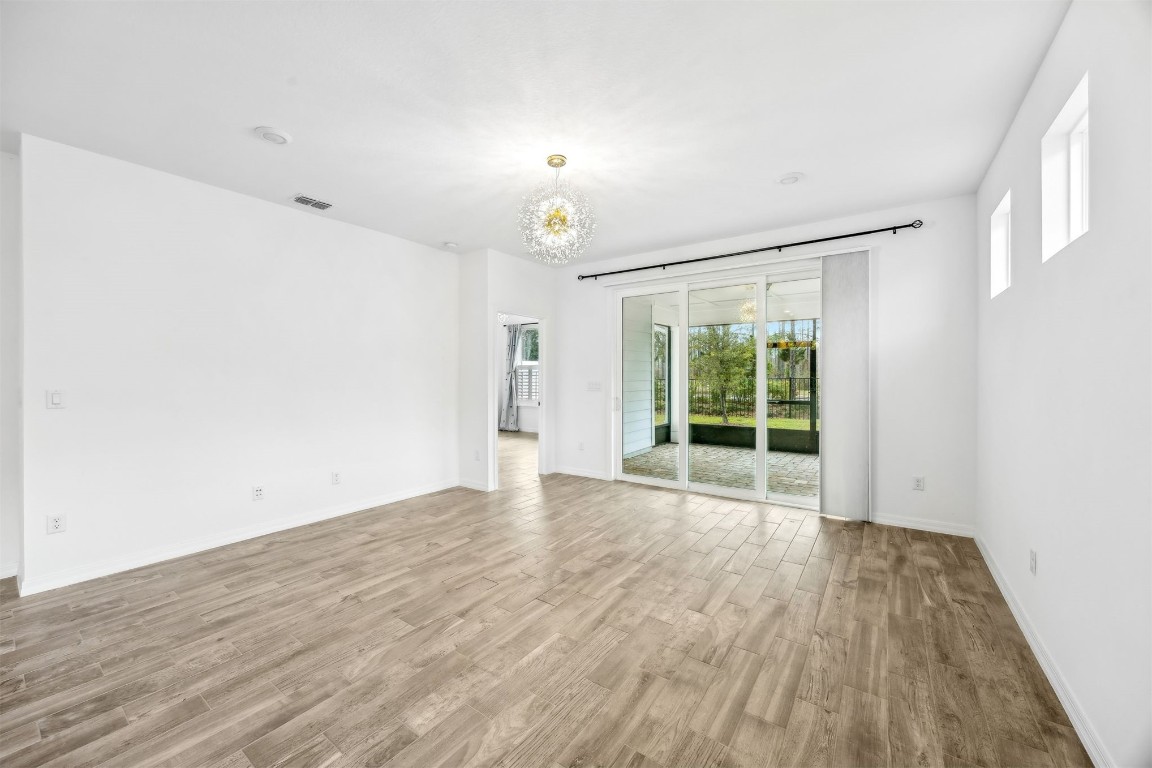 540 Jubilee Circle Yulee, FL 32097 - Photo 10 of 42 a view of an empty room with wooden floor and a window