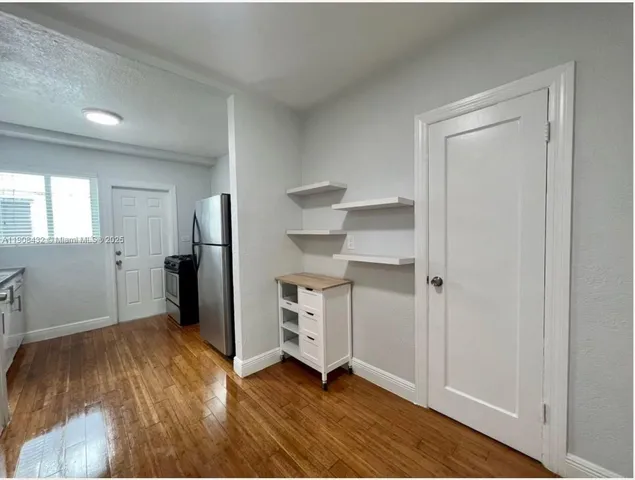 a view of empty room with wooden floor and window