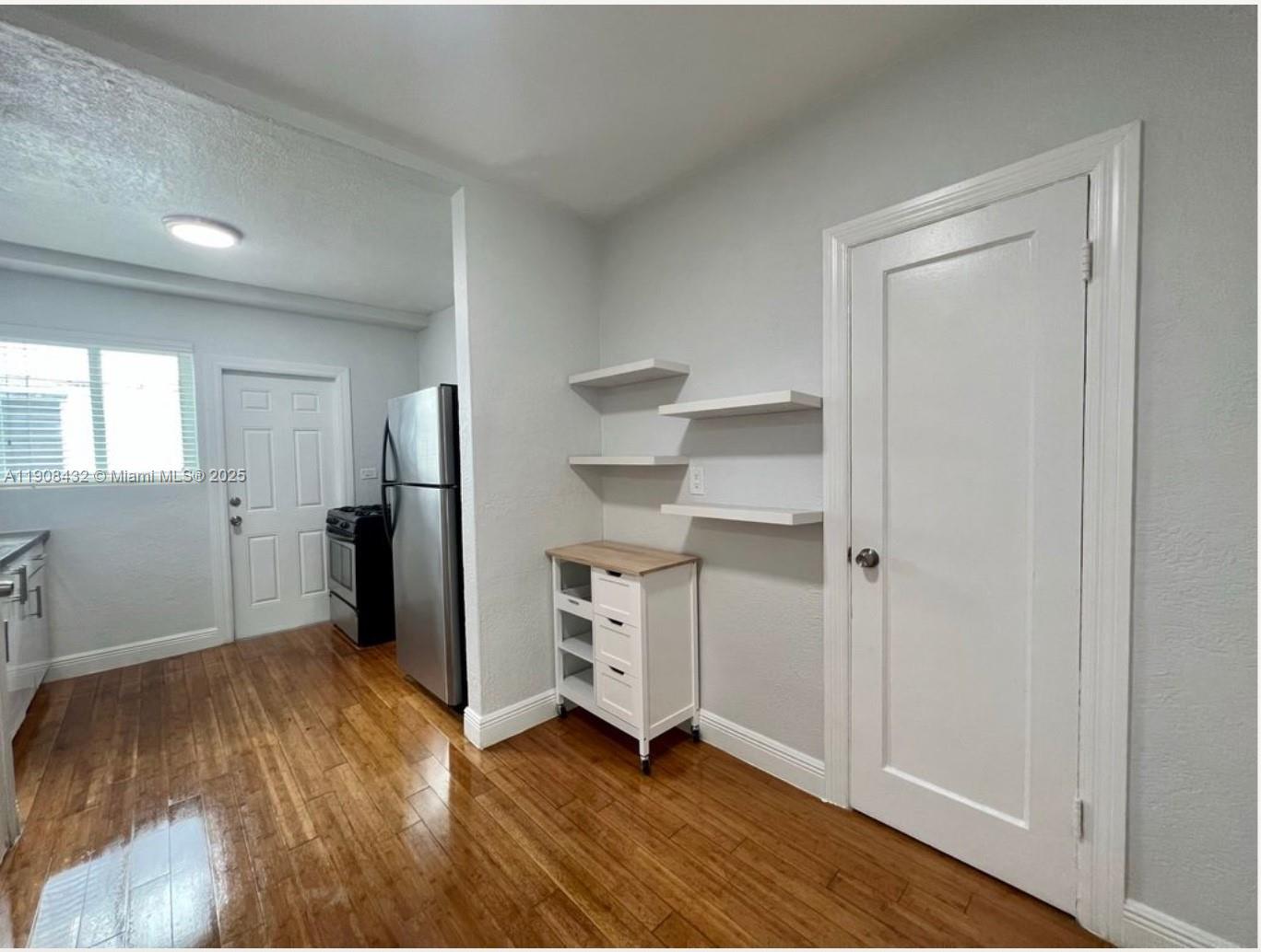 a view of empty room with wooden floor and window