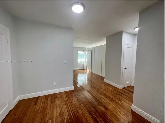 a view of an empty room and wooden floor