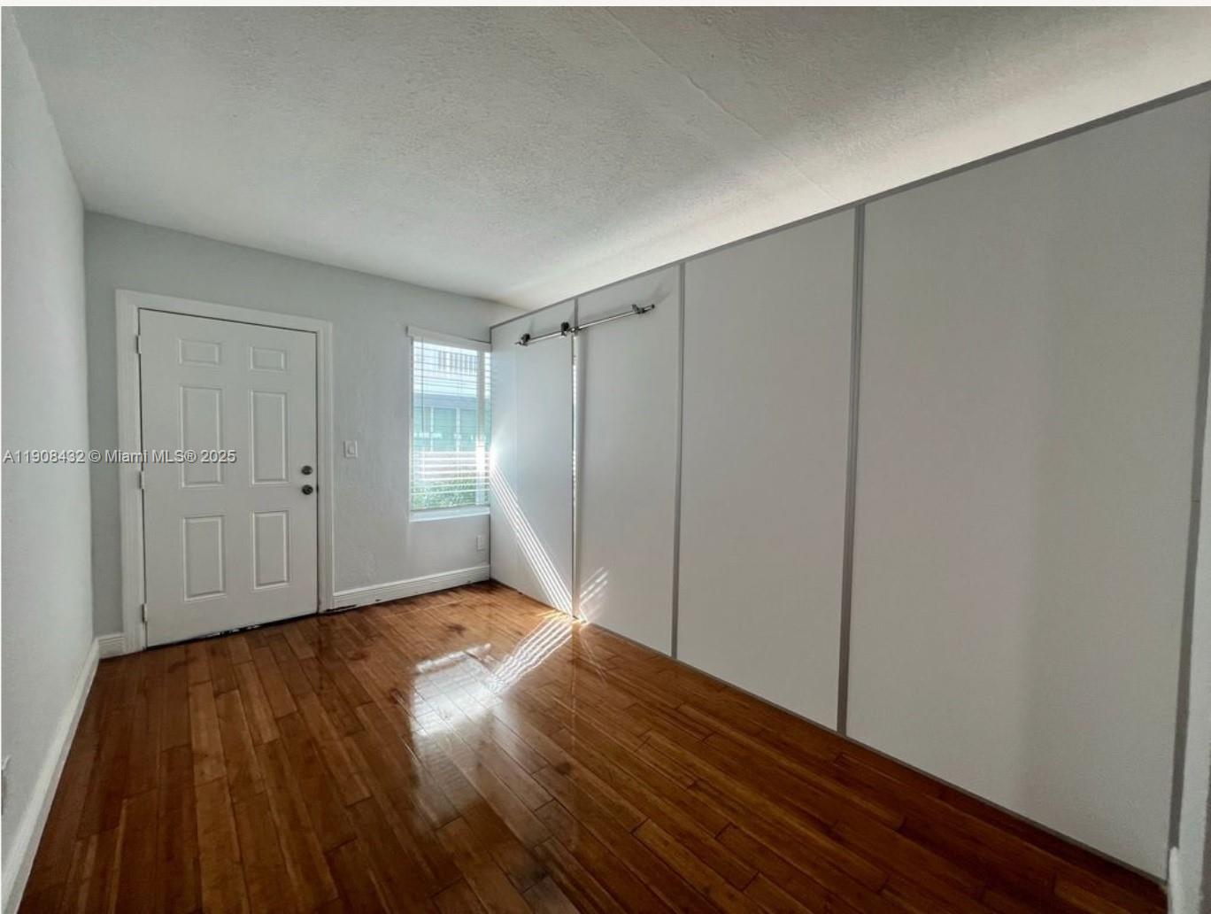 7315 Carlyle Avenue, Unit 10 Miami Beach, FL 33141 - Photo 3 of 9 a view of an empty room and wooden floor