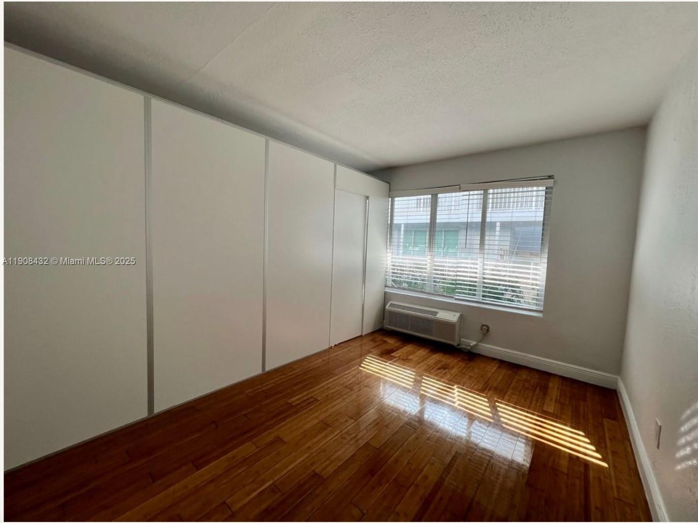 7315 Carlyle Avenue, Unit 10 Miami Beach, FL 33141 - Photo 5 of 9 a view of room with window and wooden floor