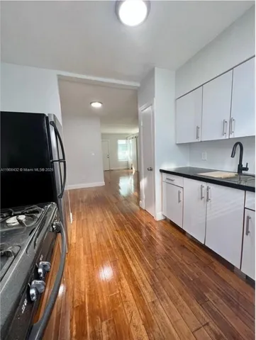 a kitchen with a sink and wooden floor