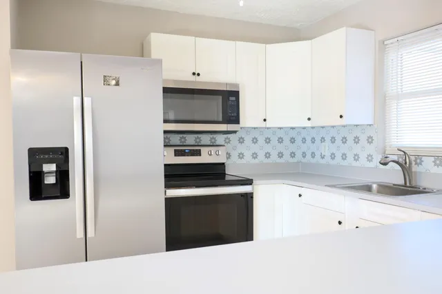 a kitchen with cabinets appliances and a window
