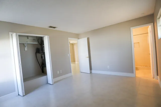 an empty room with closet and windows