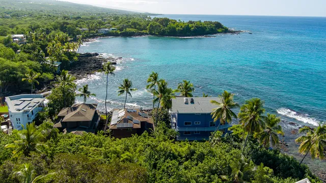 an aerial view of a house with a yard and lake view