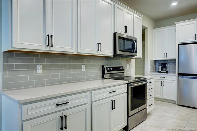 a kitchen with stainless steel appliances granite countertop a stove a sink and a refrigerator