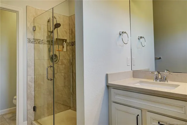 a bathroom with a shower sink and mirror