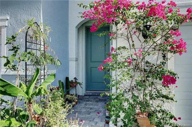 a vase of flowers sitting in front of a house
