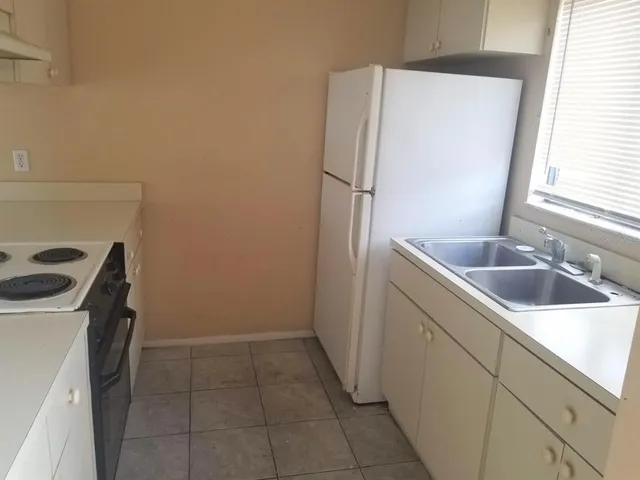 a kitchen with a sink a refrigerator and washer