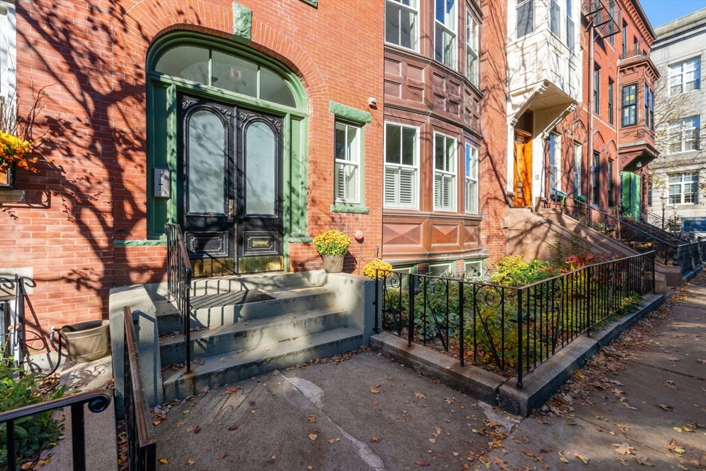 33 Monument Square, Unit 1 Boston, MA 02129 - Photo 1 of 19 a view of a brick house with large windows and a small yard