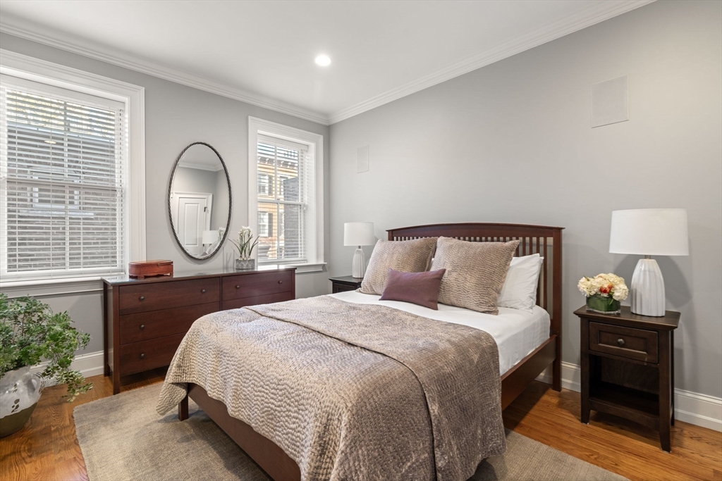 33 Monument Square, Unit 1 Boston, MA 02129 - Photo 12 of 19 a bedroom with a bed a mirror and a lamp on dresser