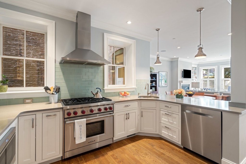 33 Monument Square, Unit 1 Boston, MA 02129 - Photo 4 of 19 a kitchen with a stove a sink and a wooden floor