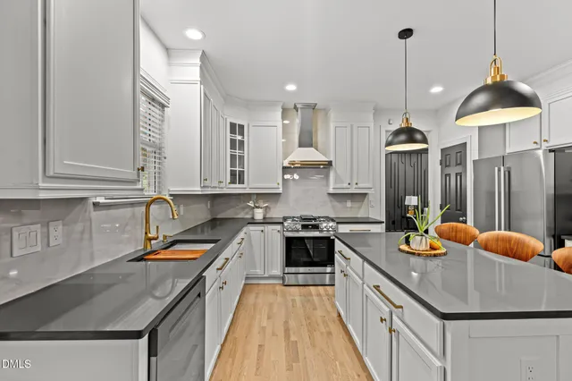 a kitchen with stainless steel appliances a stove a sink and a microwave